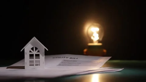 The lightbulb lights up with the utility bill and the house, financial budg.. Stock Footage 303214704