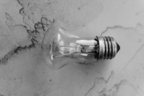 Lightbulb on a marble surface. Stock Photos
