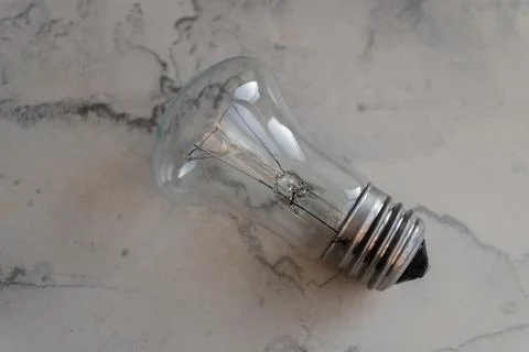 Lightbulb on a marble surface. Stock Photos