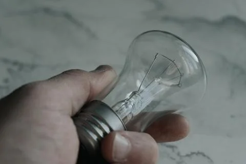 Lightbulb on a marble surface. Stock Photos