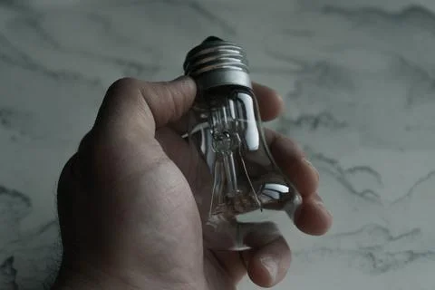 Lightbulb on a marble surface. Stock Photos