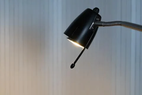 A lighted black reading lamp in front of white background with copy-space Stock Photos