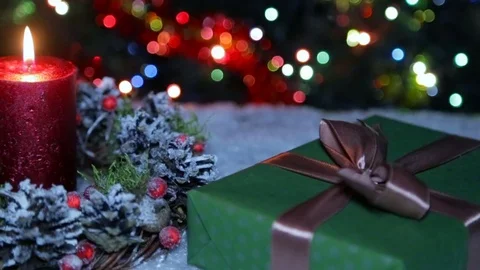 A lighted candle and a gift box on the background of a bokeh Stock Footage 82609021