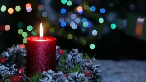 A lighted candle and a gift box on the background of a bokeh Vídeo Stock 82609170