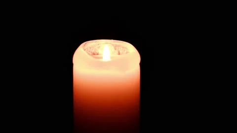 A lighted candle burns in complete darkness. Candle flame movement. Stock Footage 166569521