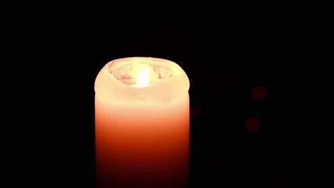 A lighted candle burns in complete darkness. Candle flame movement. 4k Stock Footage 167127253