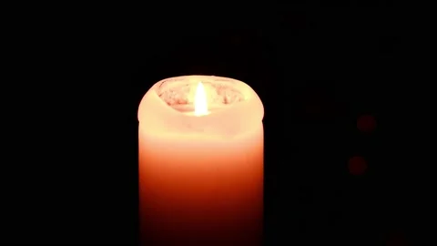 A lighted candle burns in complete darkness. Candle flame movement. 4k Stock Footage 167326706