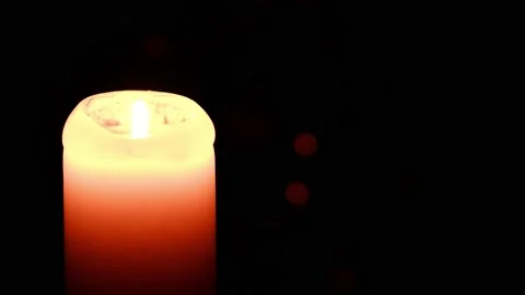 A lighted candle burns in complete darkness. Candle flame movement. 4k Stock Footage 167366133