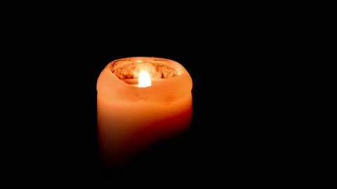 A lighted candle burns in complete darkness. Candle flame movement. 4k Stock Footage 167424221