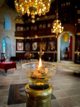 Lighted candle in front of the altar. Stock Photos