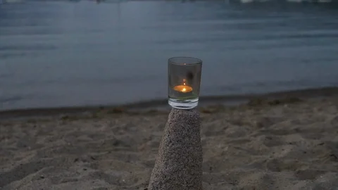 A lighted candle by the sea side 스톡 동영상 98769390