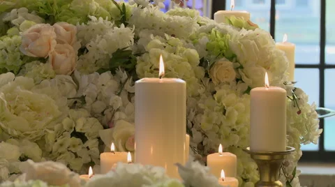 Lighted candles on backdrop of white flowers Stock Footage 44159185