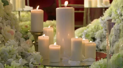 Lighted candles of different heights and flowers Stock Footage 44794858