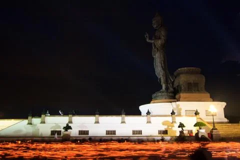 Lighted candles in hand around buddha statue Stock Photos