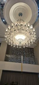 A lighted chandelier in a reception hall Stock Photos
