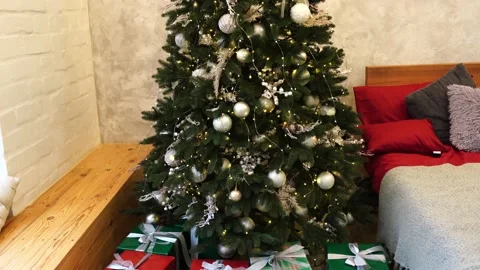 Lighted Christmas tree with presents underneath in living room Video stock 144119379