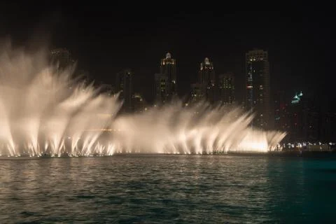 Lighted Fountains Performing Dramatic Effects along Urban Beachfront at Night Stock Photos