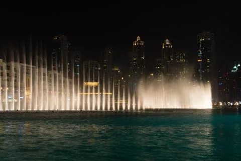 Lighted Fountains Performing Dramatic Effects along Urban Beachfront at Night Stock Photos