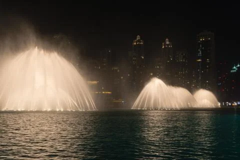 Lighted Fountains Performing Dramatic Effects along Urban Beachfront at Night Stock Photos