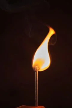 A lighted match on a dark background 스톡 사진