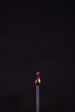 A lighted match on a dark background 스톡 사진