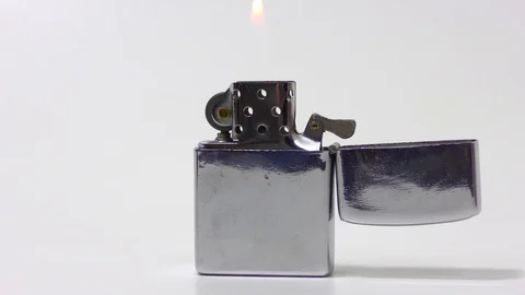 Lighted metal lighter on a white background Stock Footage 126594496