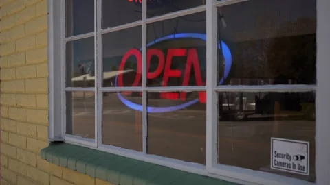 A lighted Open sign in the window of a small business Stock Footage 272614891