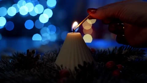 Lighted soy candle plays in the warmth against the background of Christmas tree Stock Footage 259182740
