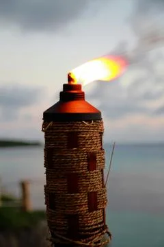 Lighted tiki torch with the wind blowing on the flames to one direction Stock Photos