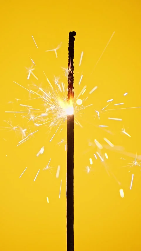 Lightening sparkler on yellow background. Firework sparkler burning with lights. Stock Footage 258291053