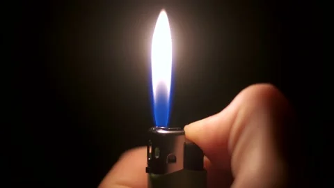 The lighter is held in the hand and lit. The lighter produces a spark Stock Footage 142044739