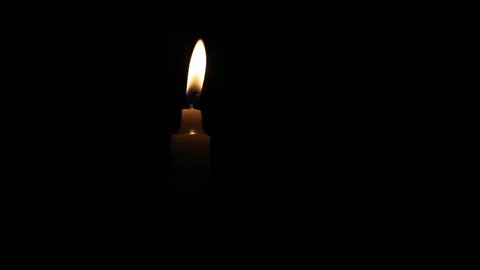 A lighter lighting a small candle in the dark. combustion process. Stock Footage 254343052