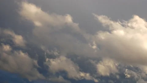 Lighter white-gray clouds move in front of a dark blue-gray cloudy background Stock Footage 134902628
