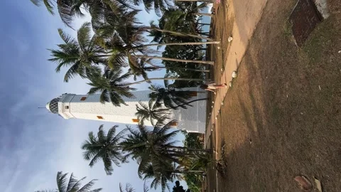 Lighthouse among palm trees by the ocean, lighthouse by the sea Stock Footage 274659217