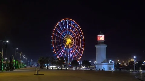 Lighthouse and Ferris wheel with light show at night 動画素材 105899758