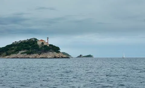 Lighthouse and sailboat Stock Photos
