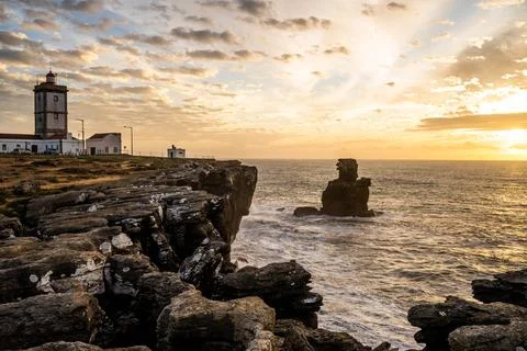 Lighthouse and sea stack on rocky headland at Peniche Portugal Stock Photos