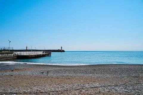 Lighthouse on the background of the sea and the sky, the sea is full calm and Stock Photos