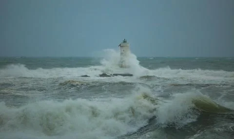Lighthouse Battling Storm Waves in Open Sea Stock Photos