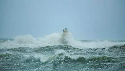 Lighthouse Battling Storm Waves in Open Sea Stock Photos