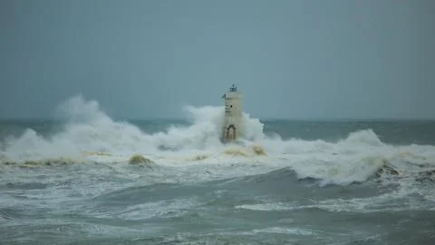 Lighthouse Battling Storm Waves in Open Sea Stock Photos