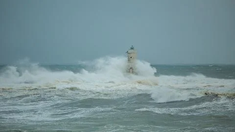 Lighthouse Battling Storm Waves in Open Sea Stock Photos
