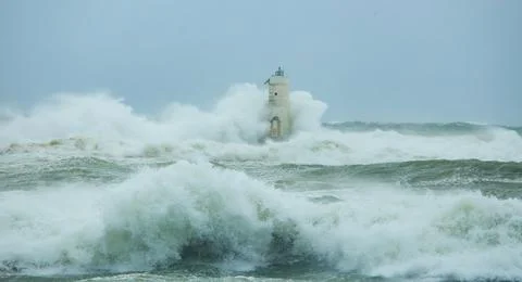 Lighthouse Battling Storm Waves in Open Sea Stock Photos