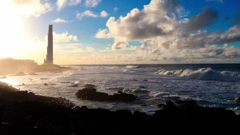 Lighthouse at the beach with ocean waves and beautiful clouds Stock Footage 246788987