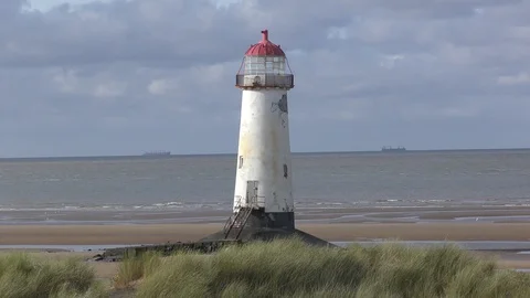 Lighthouse beach sand moving grasses Stock Footage 127416354