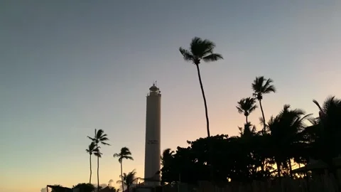 Lighthouse on the beach twinkling on the coast of the atlantic ocean at dusk Stock Footage 270483521