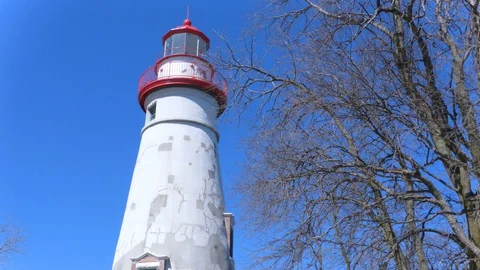 Lighthouse with Blue Sky and Dead Trees 4K Stock Footage 129452897