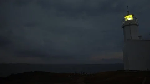 Lighthouse burning at dusk. Lighthouse light in rainy weather. 動画素材 228851006
