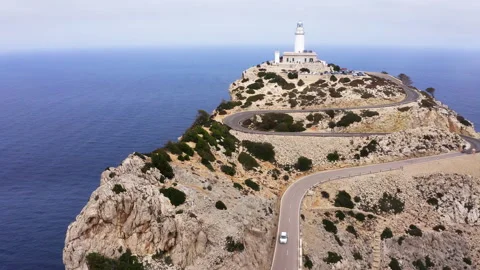 Lighthouse at Cap de Formentor with white car driving by serpentine curved aspha Stock-Footage 270034352