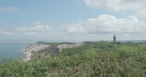 Lighthouse by the Cliffs and Beach Stockbeeldmateriaal 87540472